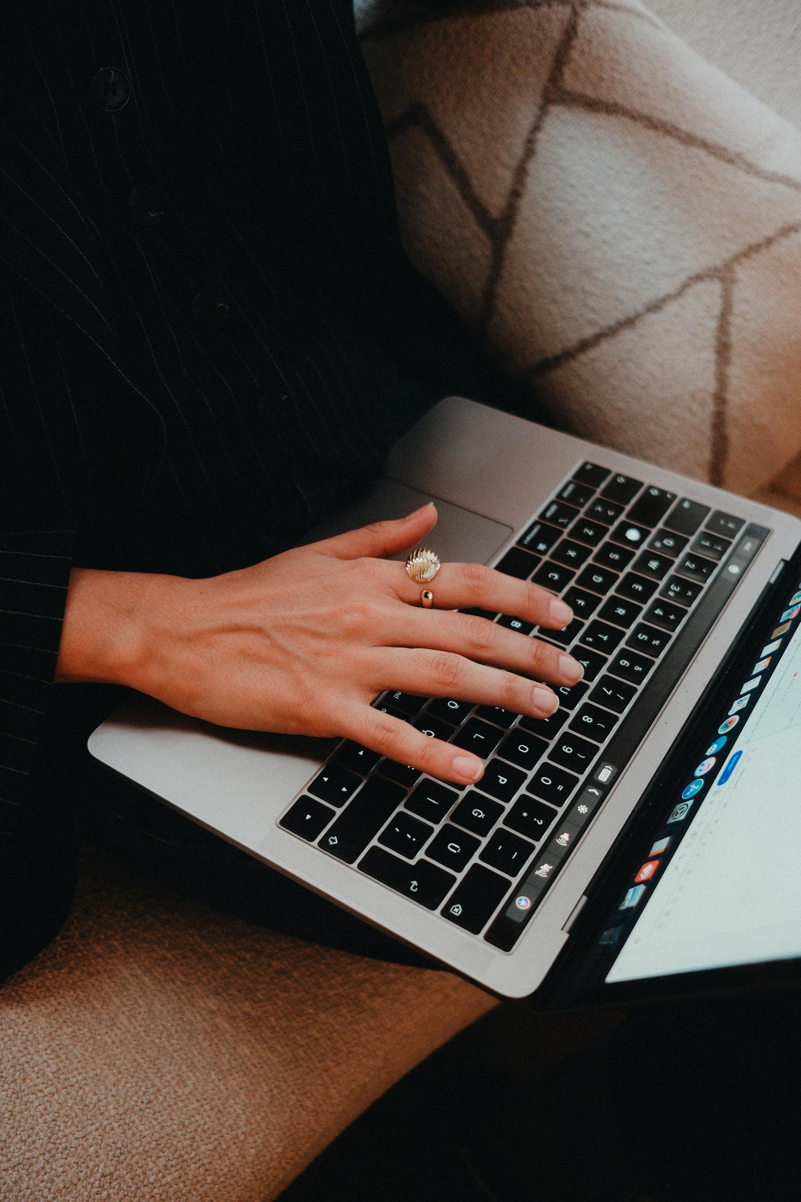 A close-up view of a person typing on a laptop keyboard with a focused hand.